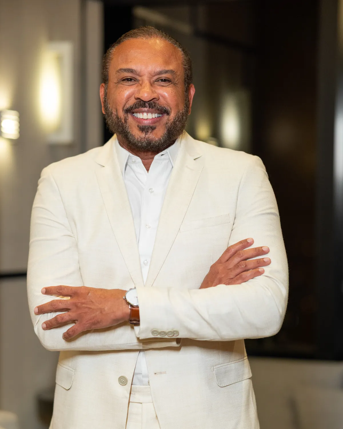 Dr. Ribamar Cruz de terno claro e braços cruzados, sorrindo.